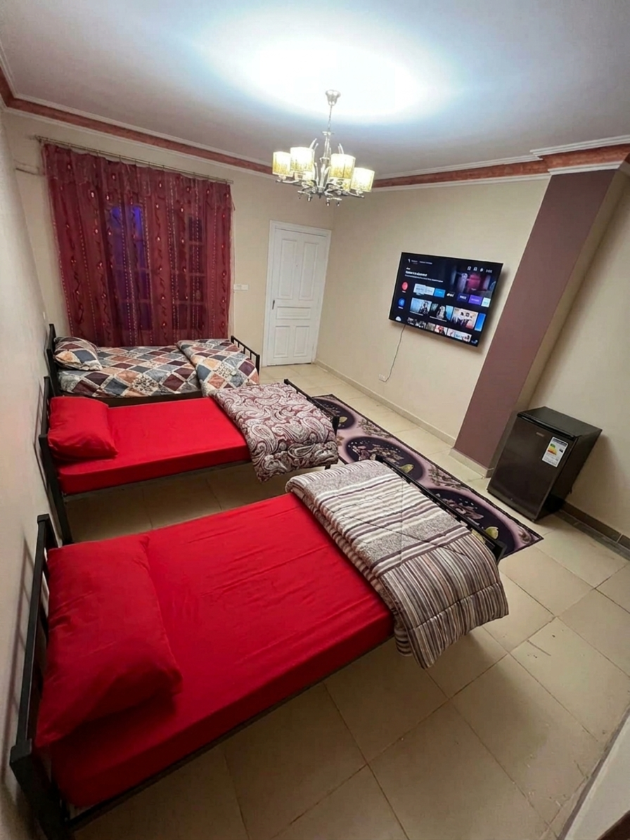 غرفة مع تلفزيون وثلاجة صغيرة ومكيف في دار شمس التعافي